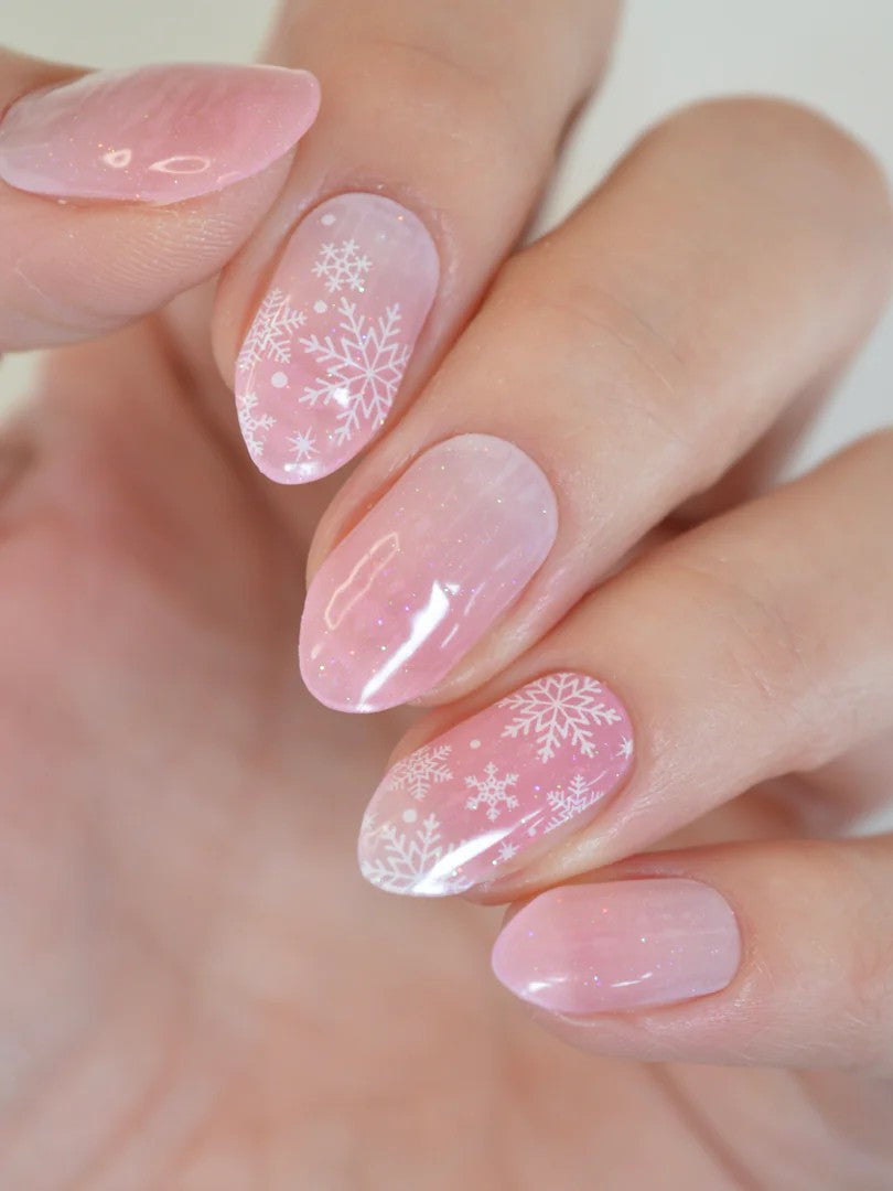 Jemný ružový gélový dizajn Flowflake Kiss s bielymi zimnými vločkami.